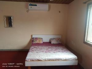 una piccola camera da letto con un letto climatizzato di Solitude villa a Badlapur