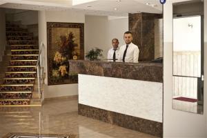 two men standing at a counter in a building at Topkapı Otel Özyavuz in Istanbul