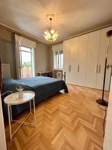 1 dormitorio con cama y mesa en el suelo de madera en HEATHER'S HOME 108 - Appartamento vista mozzafiato en Bassano del Grappa