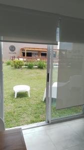 una puerta corredera de cristal con un banco en el patio en La Lucia en San Clemente del Tuyú