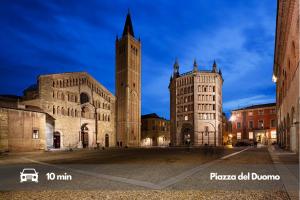 a large building with a clock tower and a church at [5 min Aeroporto-Stazione] Parma in Parma