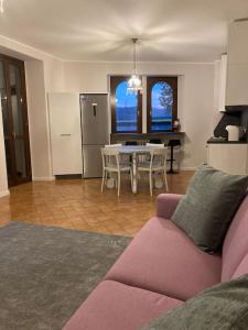 uma sala de estar com um sofá rosa e uma mesa em Residenza Le Fornaci em Sorisole