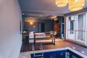 een kamer met een zwembad en een slaapkamer met een bed bij Motel Champagne by Drops in Tubarão