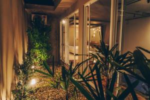 een kamer met planten en een open deur bij Motel Champagne by Drops in Tubarão