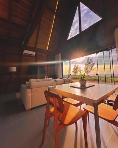 a living room with a table and chairs and a couch at O Chalé da Praia in Jaguaruna