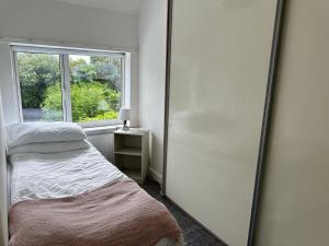 a mirror in a room with a bed and a window at 2 Bedroom House in Bloxwich