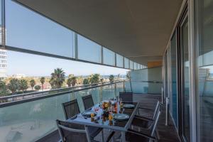 a dining room with a table and chairs on a balcony at Unique Rentals-Seafront Luxe Suites in Barcelona