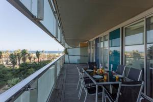 balcón con mesa, sillas y vistas al océano en Unique Rentals-Seafront Luxe Suites, en Barcelona