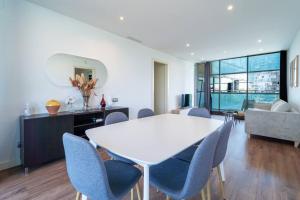 sala de estar con mesa blanca y sillas en Unique Rentals-Seafront Luxe Suites, en Barcelona