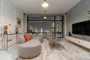 a living room with a couch and a large window at Skyline Burj Facing Suite in Dubai