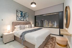 a bedroom with a large bed and a large window at Skyline Burj Facing Suite in Dubai