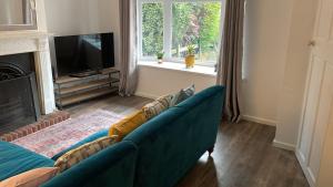 a living room with a blue couch and a television at 2 Bedroom House in Bloxwich