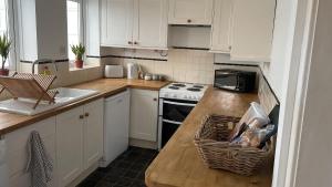 a kitchen with white cabinets and a counter top at 2 Bedroom House in Bloxwich