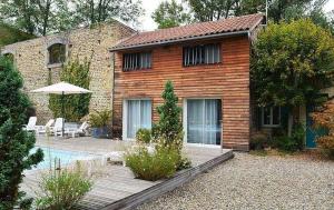 une maison en briques avec une piscine en face de celle-ci dans l'établissement Chambre d'Hôtes La Cour des Saligues, à Riscle