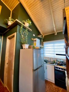 a kitchen with a refrigerator and a sink at Cabañas Los senderos del Puma in Melipeuco