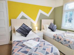 a bedroom with two beds and a wall with mountains at Epicsa - 3 Bedroom Family & Corporate Stay, Garden and FREE parking in Cambridge