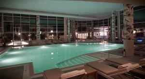 a large swimming pool with chairs in a building at UNAHOTELS MH Matera in Matera