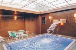 een zwembad met een fontein in een kamer bij Motel Champagne by Drops in Tubarão