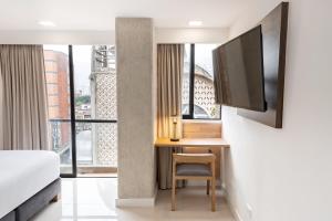 Televizorius ir (arba) pramogų centras apgyvendinimo įstaigoje Origen Local Suites