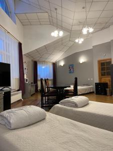 une chambre d'hôtel avec deux lits et une salle à manger dans l'établissement Narva Kangelaste 2 Apartments, à Narva