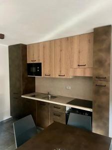 una cocina vacía con armarios de madera y fregadero en Residence Villa Linda, en Bardonecchia