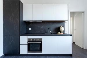 a kitchen with white cabinets and a stove at [5 min Aeroporto-Stazione] Parma in Parma