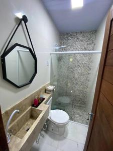 y baño con ducha, aseo y espejo. en Casa Pirangi 2, en Parnamirim