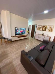 sala de estar con sofá y TV de pantalla plana en Casa Pirangi 2, en Parnamirim