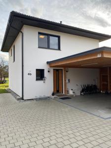 a white house with a large patio at Luxus-Anwesen mit Charme in Koblach