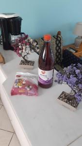 a bottle of soda sitting on a counter with flowers at Giola aparments and studios 2 in Astris