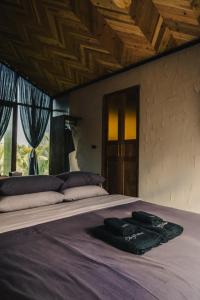 a bed with two robes on top of it at STAY PILAFarm in Ban Nam Chun Yai