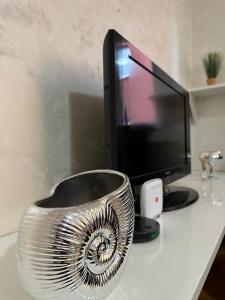 a silver bowl sitting on a desk next to a computer monitor at Čarolija in Brčko