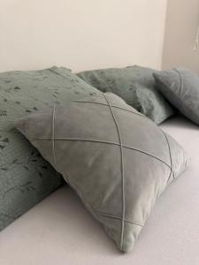 a pillow on a bed with four pillows at Čarolija in Brčko