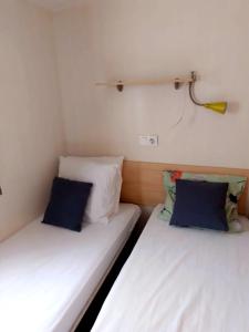 two twin beds in a small room with at Camping, mobil home équipé proche du lac de Sainte Croix et des gorges du Verdon in Sainte-Croix-de-Verdon