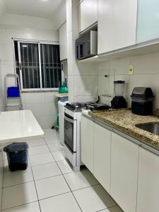 cocina blanca con fogones y fregadero en Apartamento - 3 Quartos climatizados - By BellaEstadia, en Aracaju