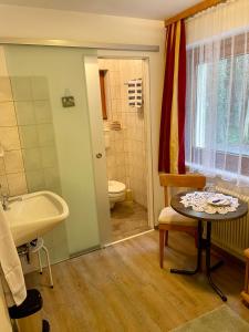 a bathroom with a sink and a toilet and a table at Haus Gröblacher in Mayrhofen