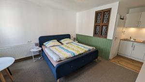 um pequeno quarto com uma cama azul num quarto em Gästezimmer Michelskeller em Sulzfeld am Main