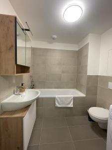 a bathroom with a tub and a sink and a toilet at SkyNest A204 in Bratislava