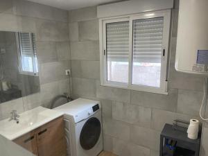 a bathroom with a washing machine and a sink at BEL APPARTEMENT ROSES PLAGE in Roses