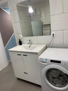 a bathroom with a washing machine and a sink at BEL APPARTEMENT ROSES PLAGE in Roses