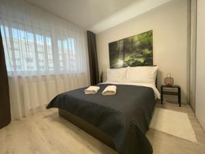 1 dormitorio con 1 cama con 2 toallas en SkyNest A204 en Bratislava