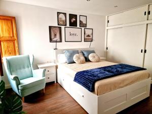 a bedroom with a bed and a blue chair at Julia's home Garachico center in Garachico