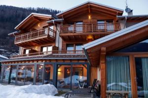 a house with glass doors and a balcony at Agritur Il Tempo delle Mele in Caldes