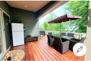 una terraza con nevera, mesa y sillas en Lake Front Cottage, 5 Star Golf Course!! Spacious, Dream Resort!!, en Keene