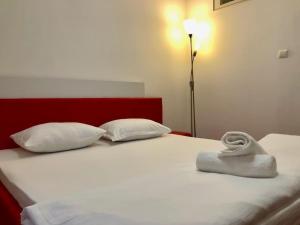 ein Bett mit zwei Kissen und einem Handtuch darauf in der Unterkunft Joy City Stay Martirilor Giroc 4 in Timişoara