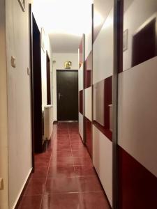 einen Flur mit schwarzer Tür und Fliesenboden in der Unterkunft Joy City Stay Martirilor Giroc 4 in Timişoara