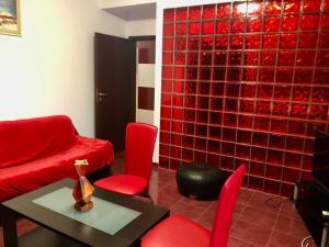 ein Wohnzimmer mit roten Stühlen und einer roten Wand in der Unterkunft Joy City Stay Martirilor Giroc 4 in Timişoara + 27 Fotos