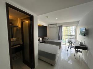 Cette chambre comprend un lit, une table et un bureau. dans l'établissement Cebu Condo Hotel Daily Rent, à Cebu