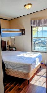1 dormitorio con 1 cama grande y ventana en Lake Front Cottage, 5 Star Golf Course!! Spacious, Dream Resort!!, en Keene