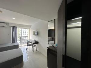 een slaapkamer met een bed, een bureau en een tafel bij Cebu Condo Hotel Daily Rent in Cebu City